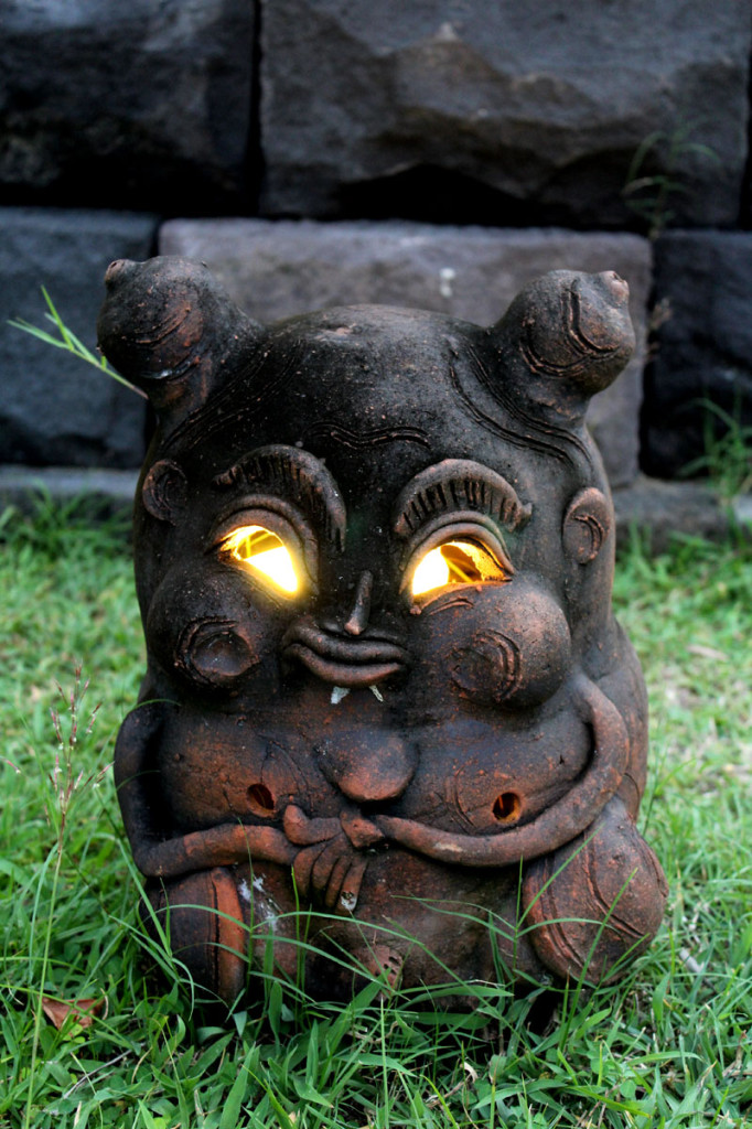 Creepy statue lit up on the sunset boardwalk in Sanur